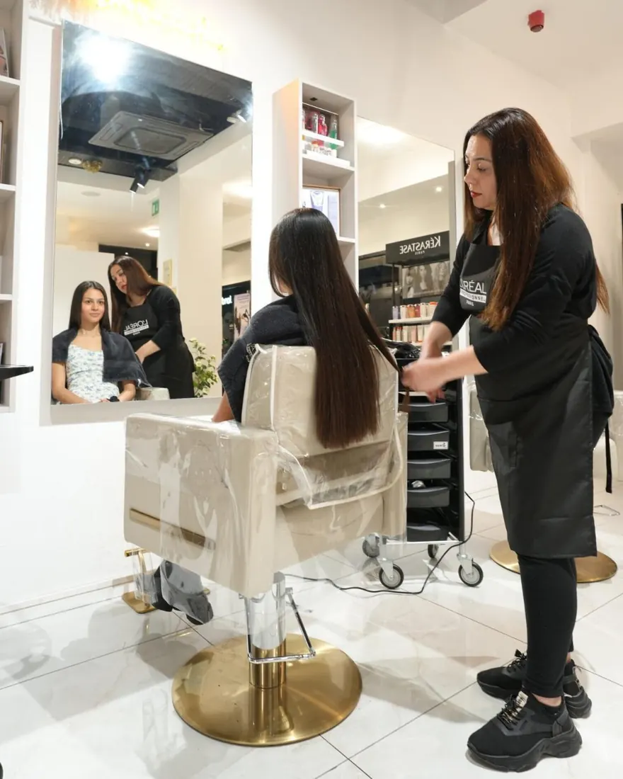 A stylist sectioning a client's hair at a styling station