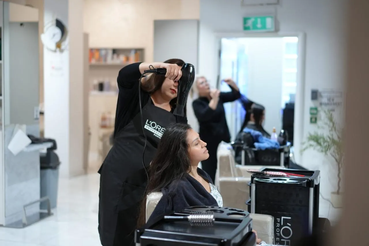 A stylist blow-drying a client's hair